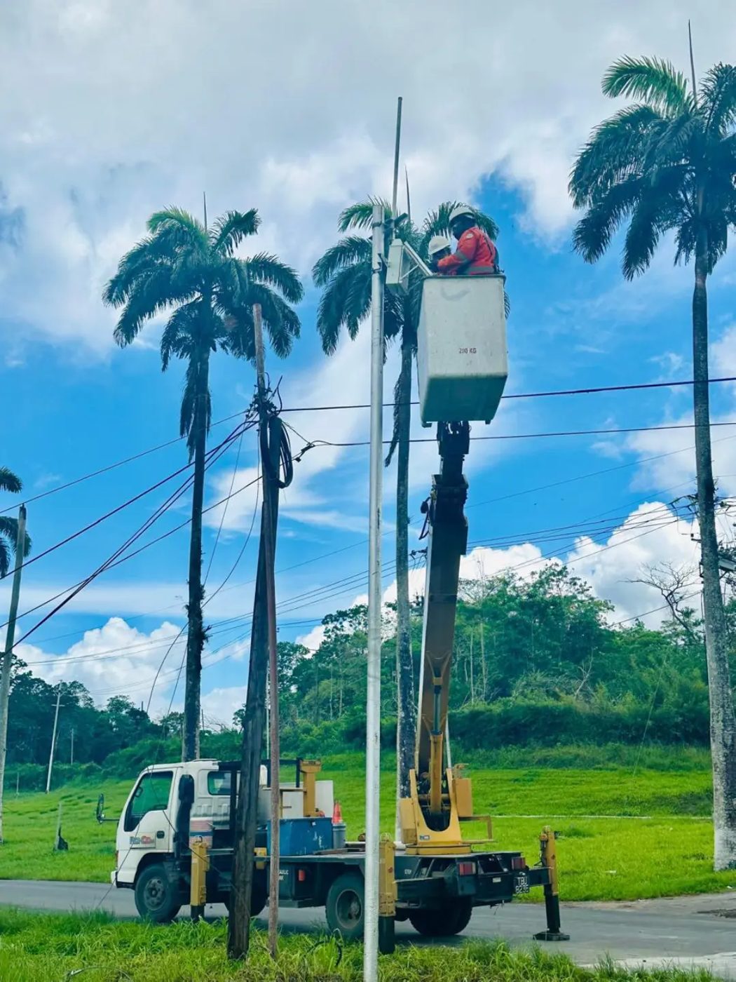 Ronco crew working from an insulated bucket truck on overhead distribution lines